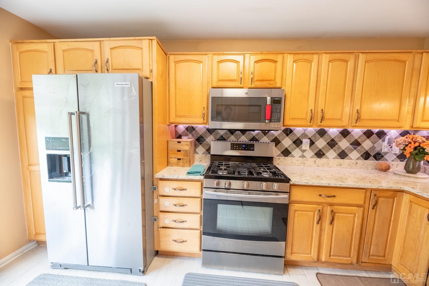 4602 Stonehedge Road Edison, NJ 08820 - Photo 44 of 87 a kitchen with stainless steel appliances granite countertop a stove a refrigerator and a microwave
