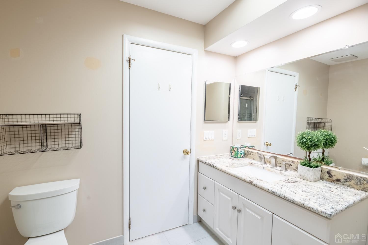 4602 Stonehedge Road Edison, NJ 08820 - Photo 56 of 87 a bathroom with a granite countertop sink toilet and mirror