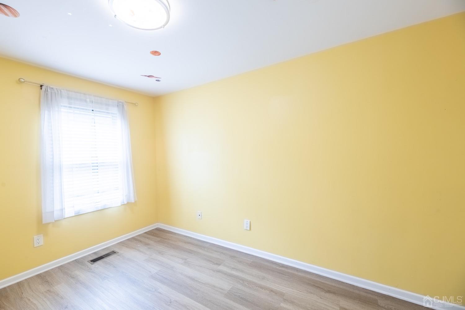4602 Stonehedge Road Edison, NJ 08820 - Photo 64 of 87 a view of an empty room with wooden floor and a window
