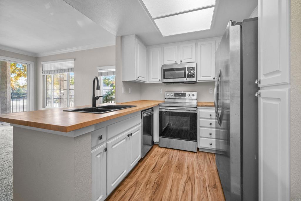 a kitchen with stainless steel appliances a stove top oven a sink and a refrigerator