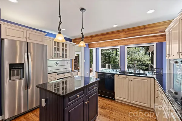 a kitchen with granite countertop a refrigerator and a sink