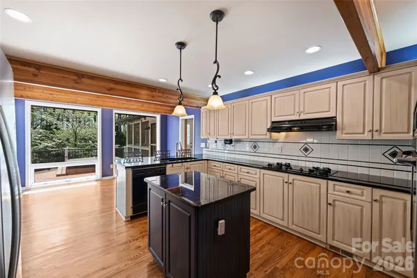 a kitchen with kitchen island granite countertop a sink counter and cabinets