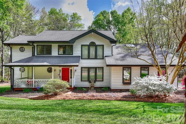 a front view of a house with a garden and plants