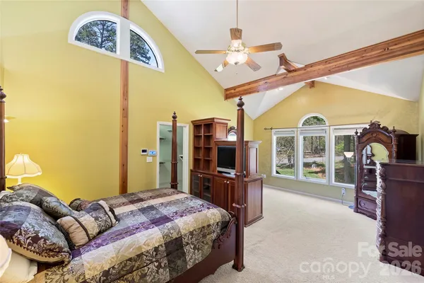 a bedroom with a bed dresser and a flat tv screen