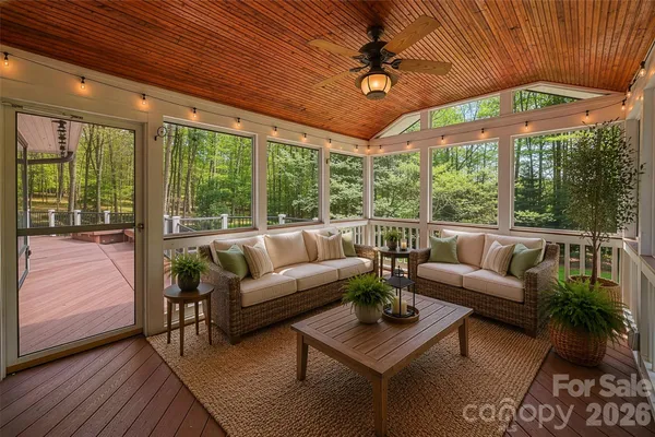a living room with furniture a ceiling fan and a large window