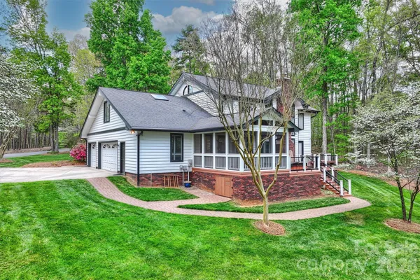 a view of a house with a yard deck and a large tree
