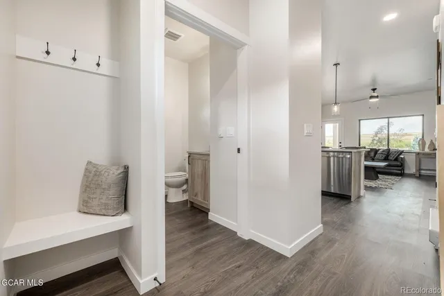 a view of a hallway with bathroom and wooden floor
