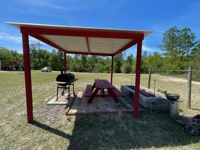 304 St James Road DeFuniak Springs, FL 32433 - Photo 14 of 37 a view of yard with table and chairs under an umbrella