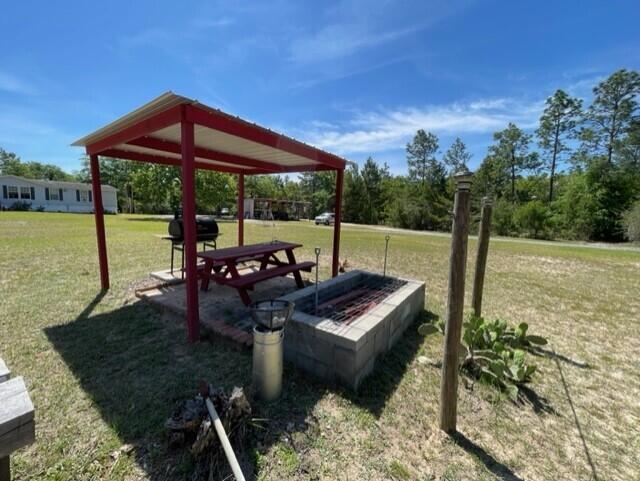 304 St James Road DeFuniak Springs, FL 32433 - Photo 17 of 37 a view of a backyard with table and chairs under an umbrella