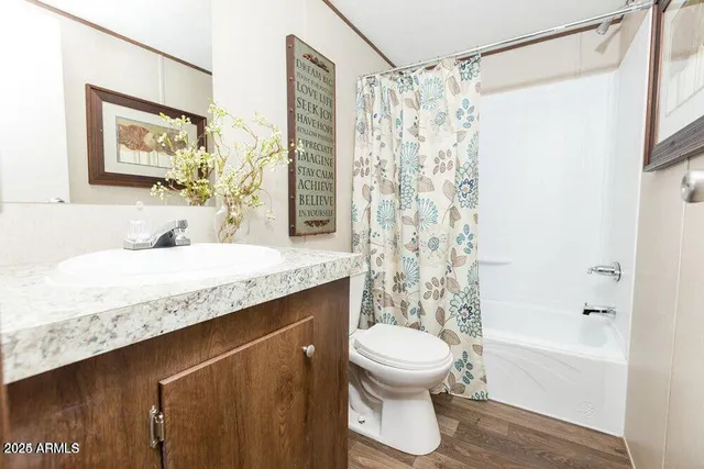 a bathroom with a granite countertop sink a toilet and shower