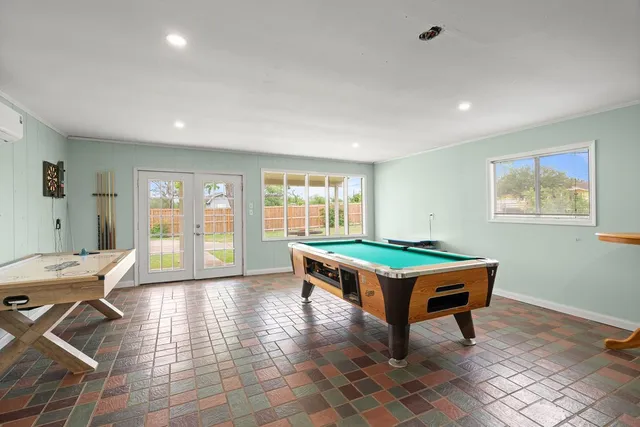 a room with pool table and window