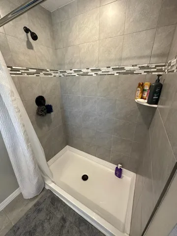 a bathroom with a sink a toilet a mirror and shower