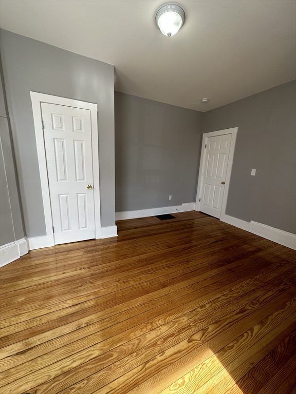 35 Harvard Street, Unit 2 Boston, MA 02124 - Photo 11 of 22 a view of an empty room with wooden floor