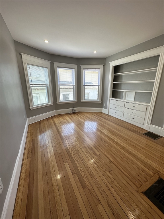 35 Harvard Street, Unit 2 Boston, MA 02124 - Photo 13 of 22 a view of an empty room with wooden floor and window