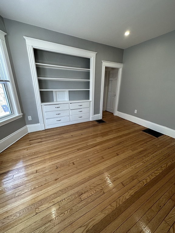 35 Harvard Street, Unit 2 Boston, MA 02124 - Photo 14 of 22 a view of an empty room with wooden floor and a window