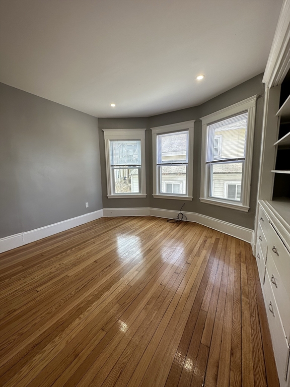 35 Harvard Street, Unit 2 Boston, MA 02124 - Photo 16 of 22 a view of an empty room with wooden floor and a window