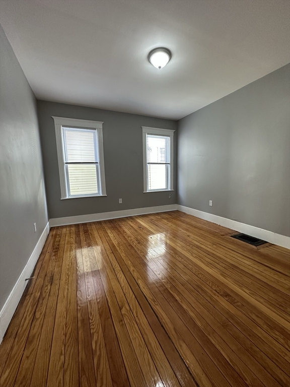 35 Harvard Street, Unit 2 Boston, MA 02124 - Photo 17 of 22 an empty room with wooden floor and windows