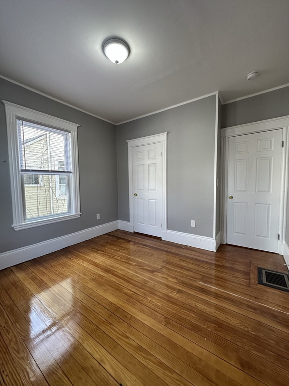 35 Harvard Street, Unit 2 Boston, MA 02124 - Photo 21 of 22 an empty room with wooden floor and windows