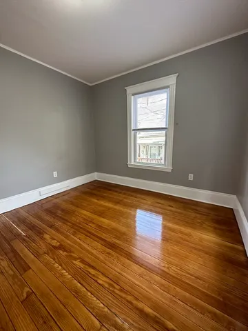 a view of a room with wooden floor and window