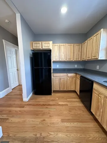 a kitchen with granite countertop a refrigerator and a sink