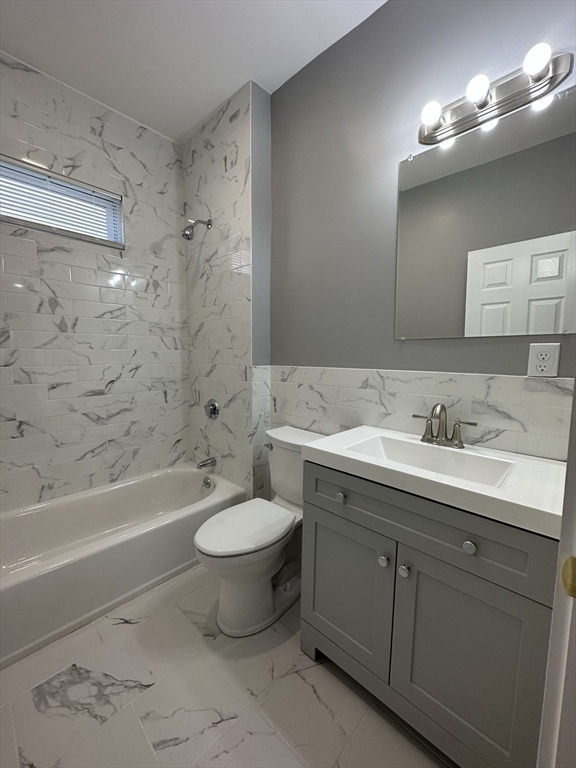 35 Harvard Street, Unit 2 Boston, MA 02124 - Photo 5 of 22 a bathroom with a toilet a sink a mirror a bathtub and vanity