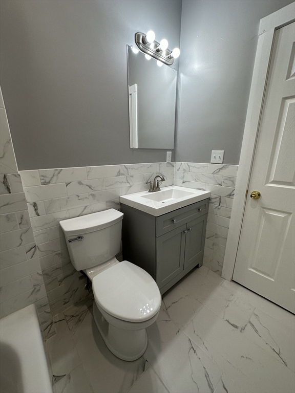35 Harvard Street, Unit 2 Boston, MA 02124 - Photo 6 of 22 a bathroom with a toilet sink and mirror