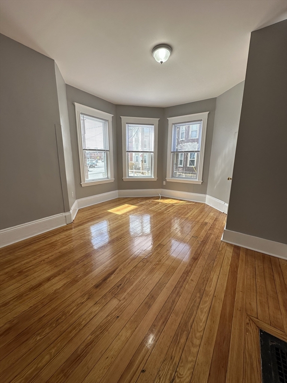 35 Harvard Street, Unit 2 Boston, MA 02124 - Photo 9 of 22 a view of empty room with wooden floor and fan