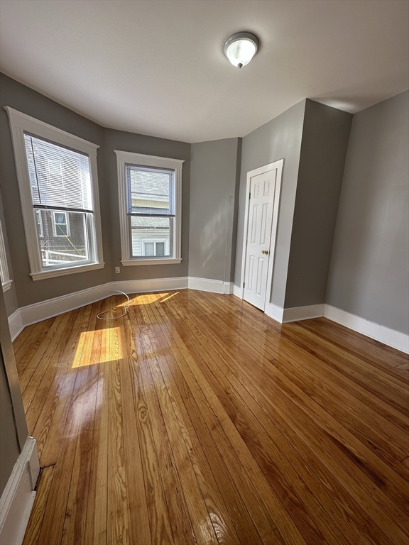 35 Harvard Street, Unit 2 Boston, MA 02124 - Photo 10 of 22 an empty room with wooden floor and windows