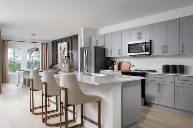 a kitchen with stainless steel appliances granite countertop a stove a sink a microwave and a refrigerator