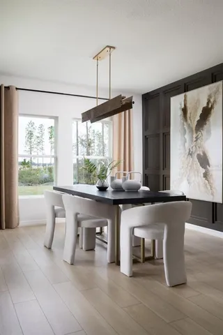 a living room with furniture large window and wooden floor