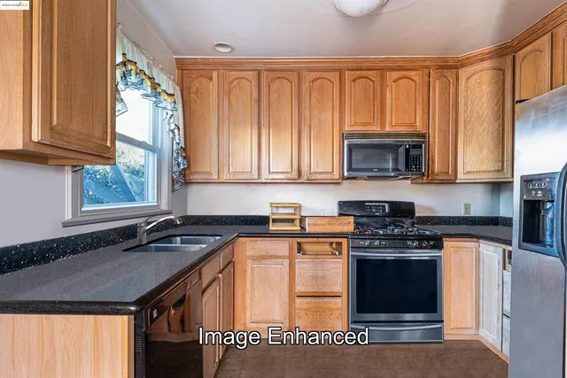 a kitchen with stainless steel appliances granite countertop a stove a sink and a microwave