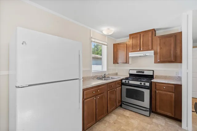 a kitchen with stainless steel appliances granite countertop a stove a refrigerator and a sink