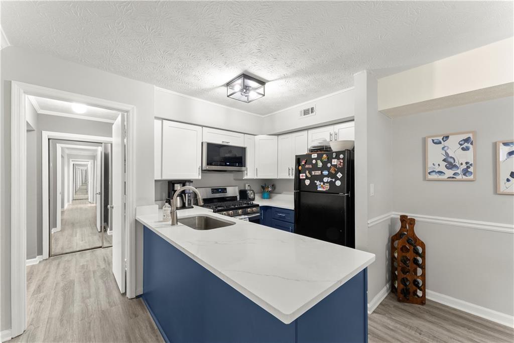 1997 Brian Way Decatur, GA 30033 - Photo 8 of 27 a kitchen with a refrigerator a sink dishwasher and white cabinets with wooden floor