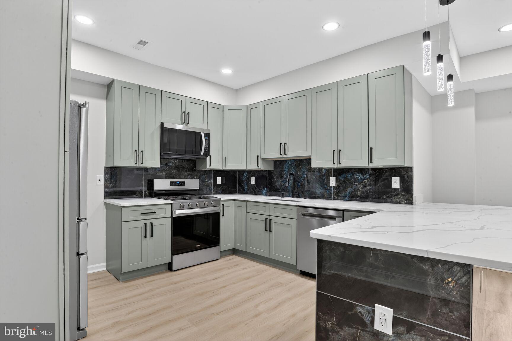 4013 4th Street Baltimore, MD 21225 - Photo 7 of 35 a kitchen with a sink stove and white cabinets
