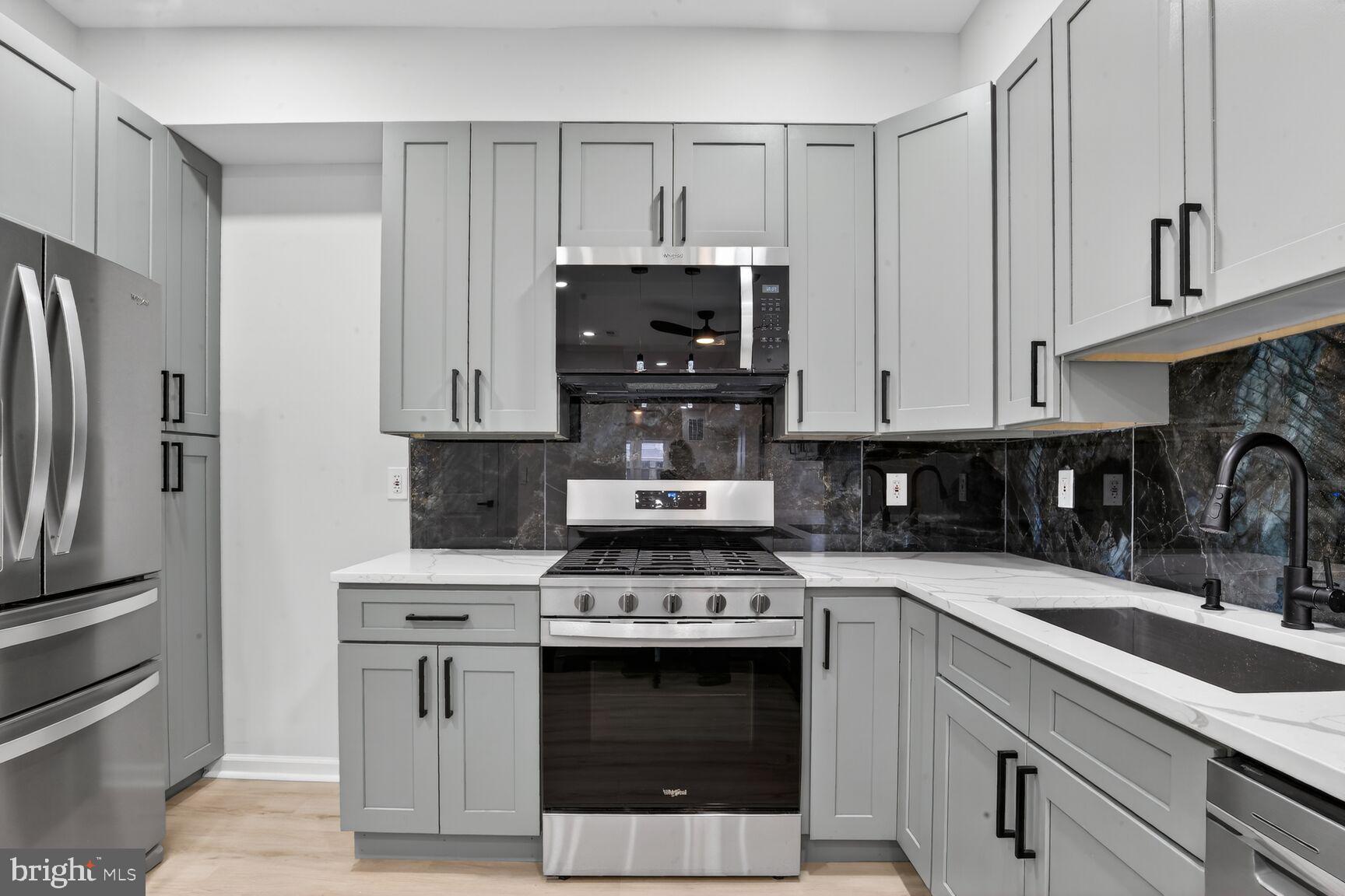 4013 4th Street Baltimore, MD 21225 - Photo 8 of 35 a kitchen with stainless steel appliances granite countertop a stove a refrigerator and a sink