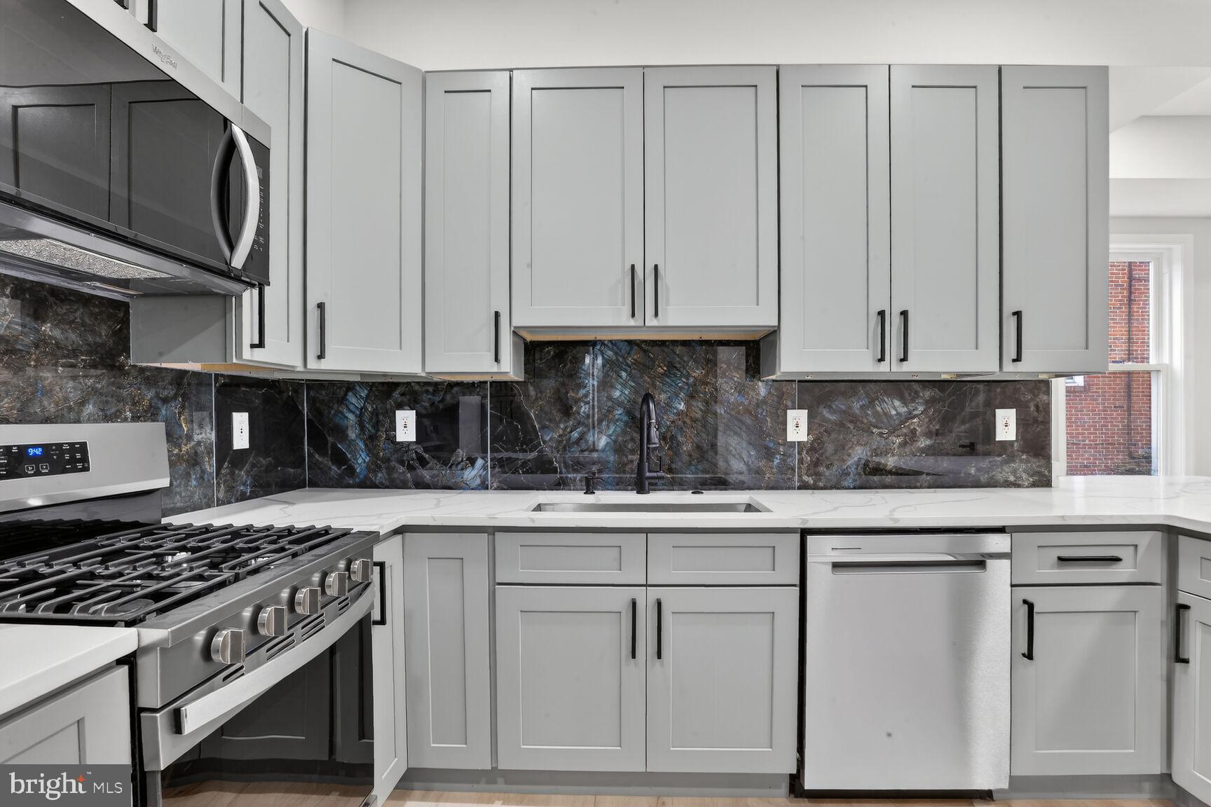 4013 4th Street Baltimore, MD 21225 - Photo 9 of 35 a kitchen with white cabinets and white appliances