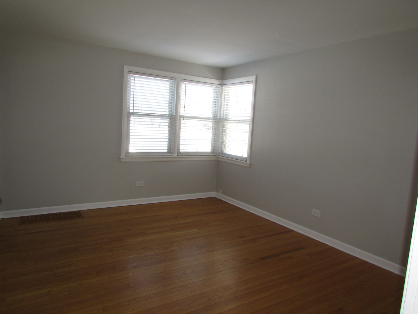 309 East Golf Road Des Plaines, IL 60016 - Photo 3 of 27 an empty room with wooden floor and windows