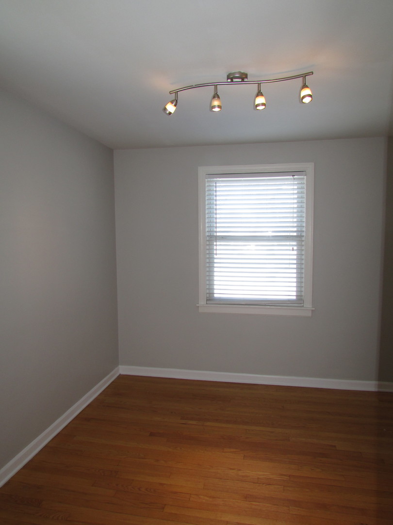 309 East Golf Road Des Plaines, IL 60016 - Photo 9 of 27 a view of an empty room with wooden floor and a window