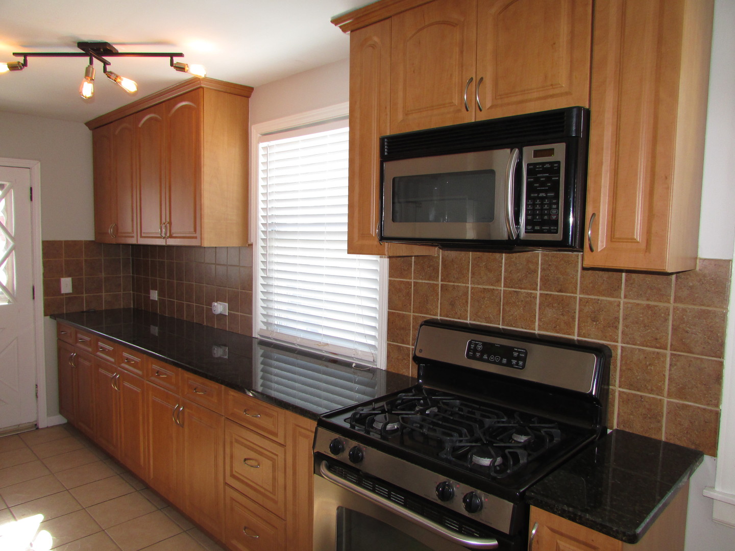 309 East Golf Road Des Plaines, IL 60016 - Photo 10 of 27 a kitchen with granite countertop stove top oven and cabinets