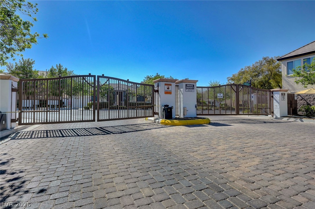 977 Sparkling Light Street Henderson, NV 89052 - Photo 68 of 75 Secure community entrance with attractive paver driveway and stately gate.