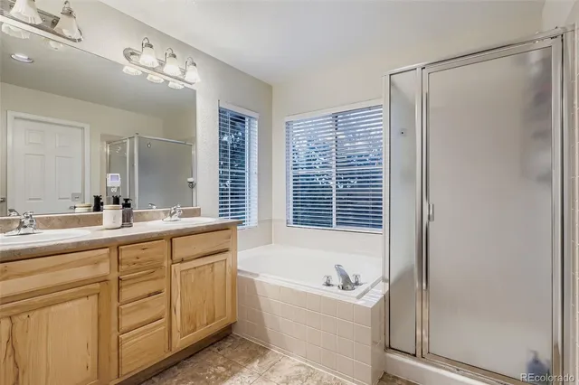 a bathroom with a tub a sink and a large mirror