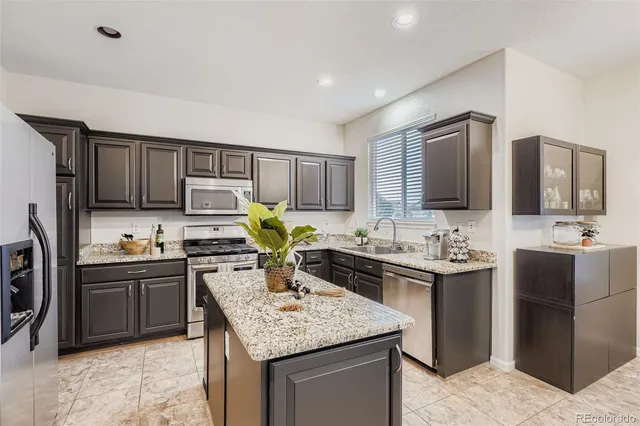a kitchen with kitchen island granite countertop a sink stove and cabinets
