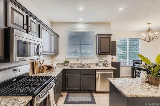 a kitchen with stainless steel appliances granite countertop a stove and a sink