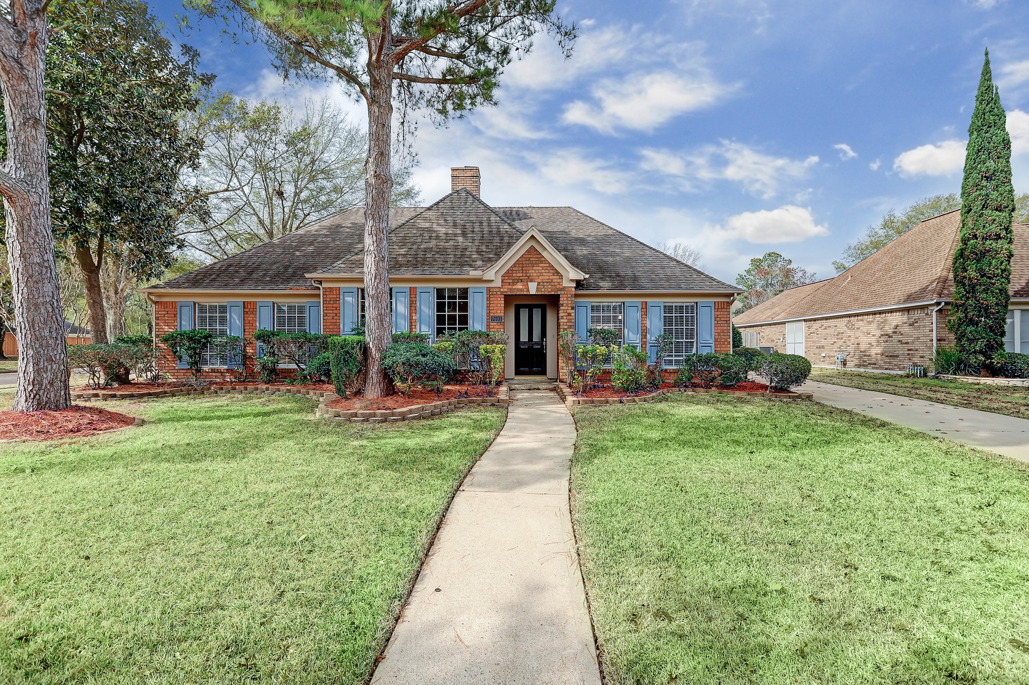 a front view of a house with yard and green space