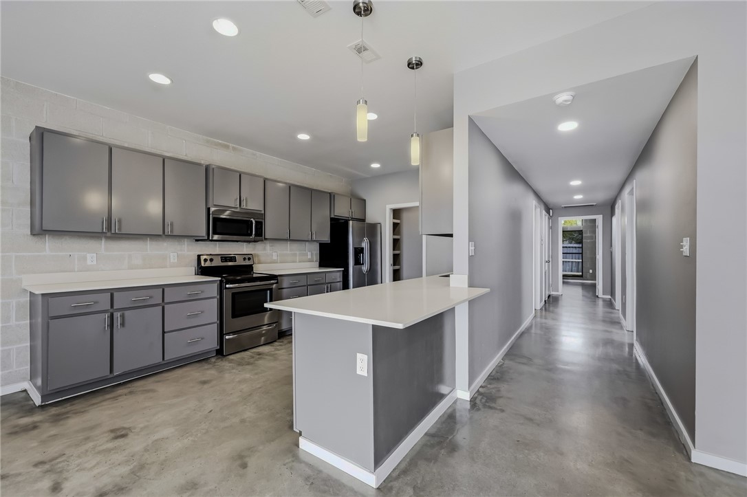 306 Easy Street, Unit B Corpus Christi, TX 78418 - Photo 7 of 24 a kitchen with stainless steel appliances kitchen island granite countertop a refrigerator and a sink