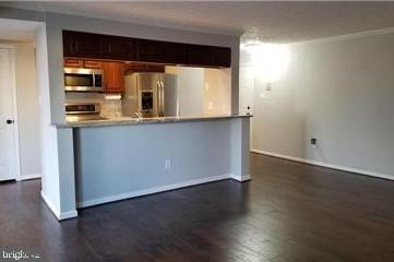 603 Himes Avenue, Unit 106 Frederick, MD 21703 - Photo 5 of 13 an empty room with wooden floor and windows