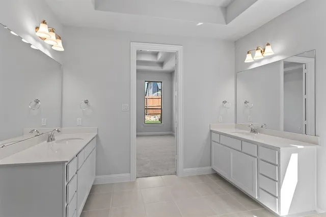 a spacious bathroom with double vanity a mirror a vanity and a bathtub