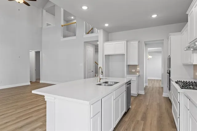 a kitchen with stainless steel appliances granite countertop a sink stove and refrigerator