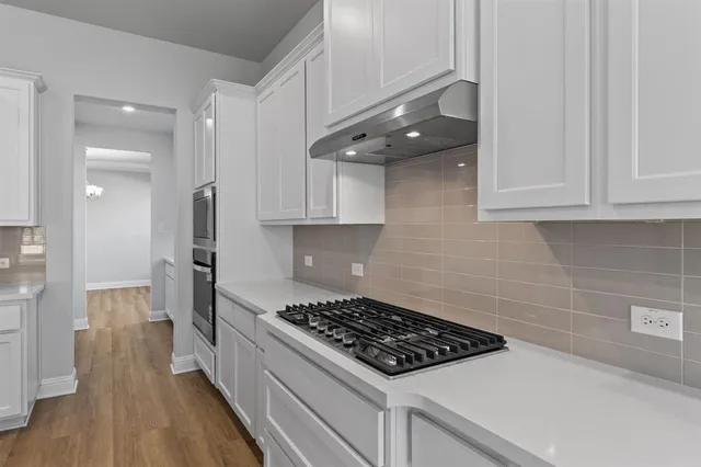 a kitchen with stainless steel appliances a stove a refrigerator and cabinets