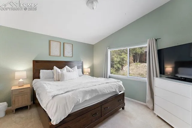 a bedroom with a bed and a flat tv screen on dresser